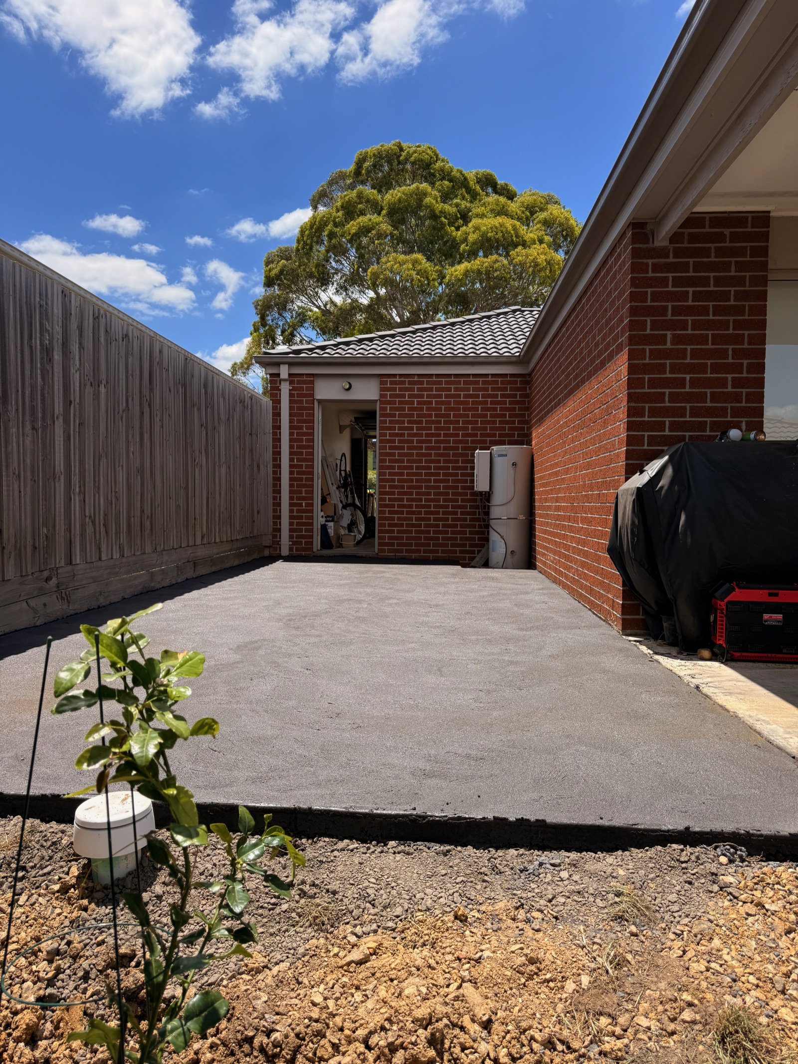 Completed concrete side access beside a brick home